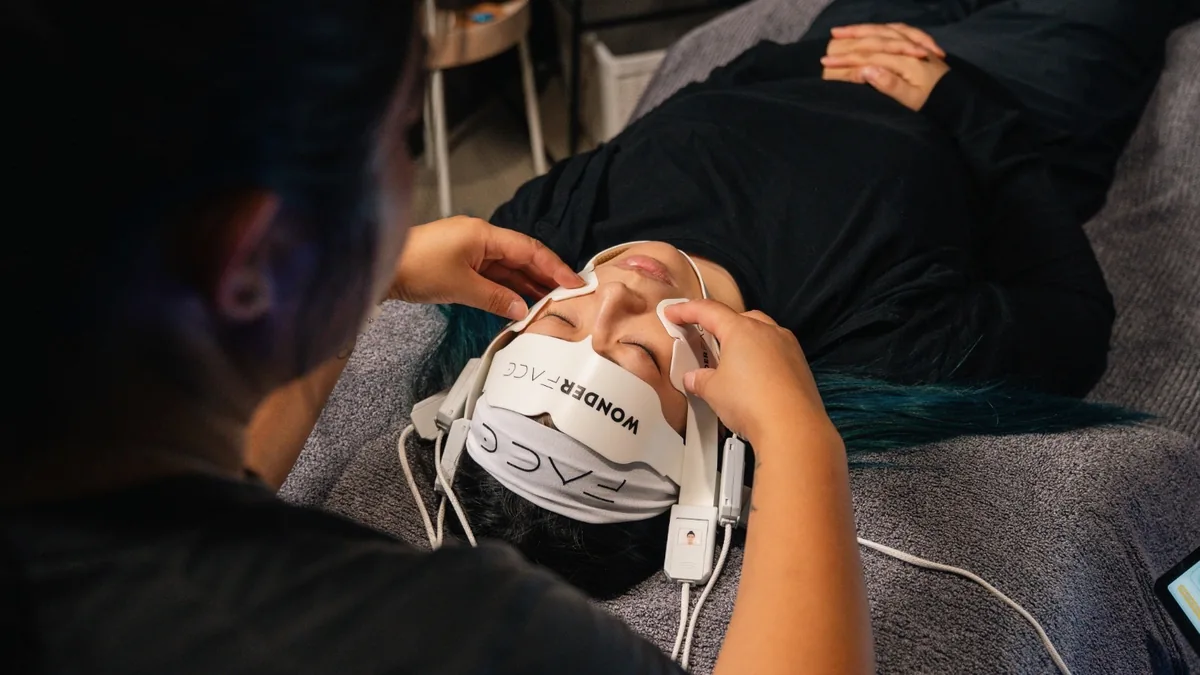 WonderFace facial contouring treatment in progress at Kaizen Therapy — practitioner positioning the branded WonderFace device on a client during a 25-minute session